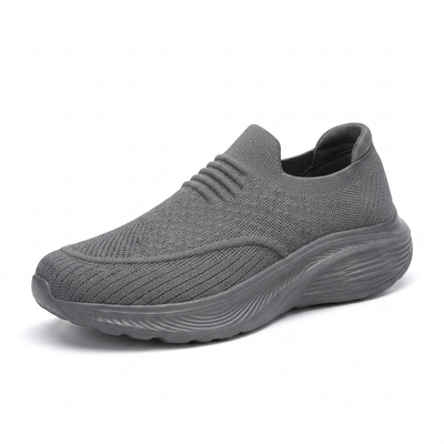 Grå slip-on komfortsko unisex med stötdämpande sula och stretchigt sticktyg mot vit bakgrund