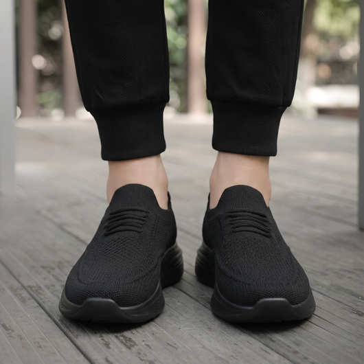 Svarta slip-on komfortskor unisex burna utomhus på trädäck, vy framifrån