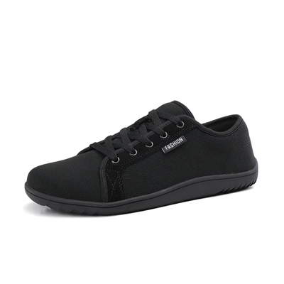 Svart minimalistisk barfotasko unisex med bred tåbox och zero drop-sula mot vit bakgrund