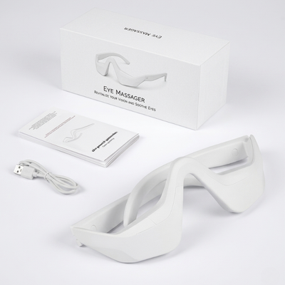InfraRelief™ Ögonmassager produktpaket – vit enhet, USB-laddningskabel, användarmanual och förpackning mot vit bakgrund