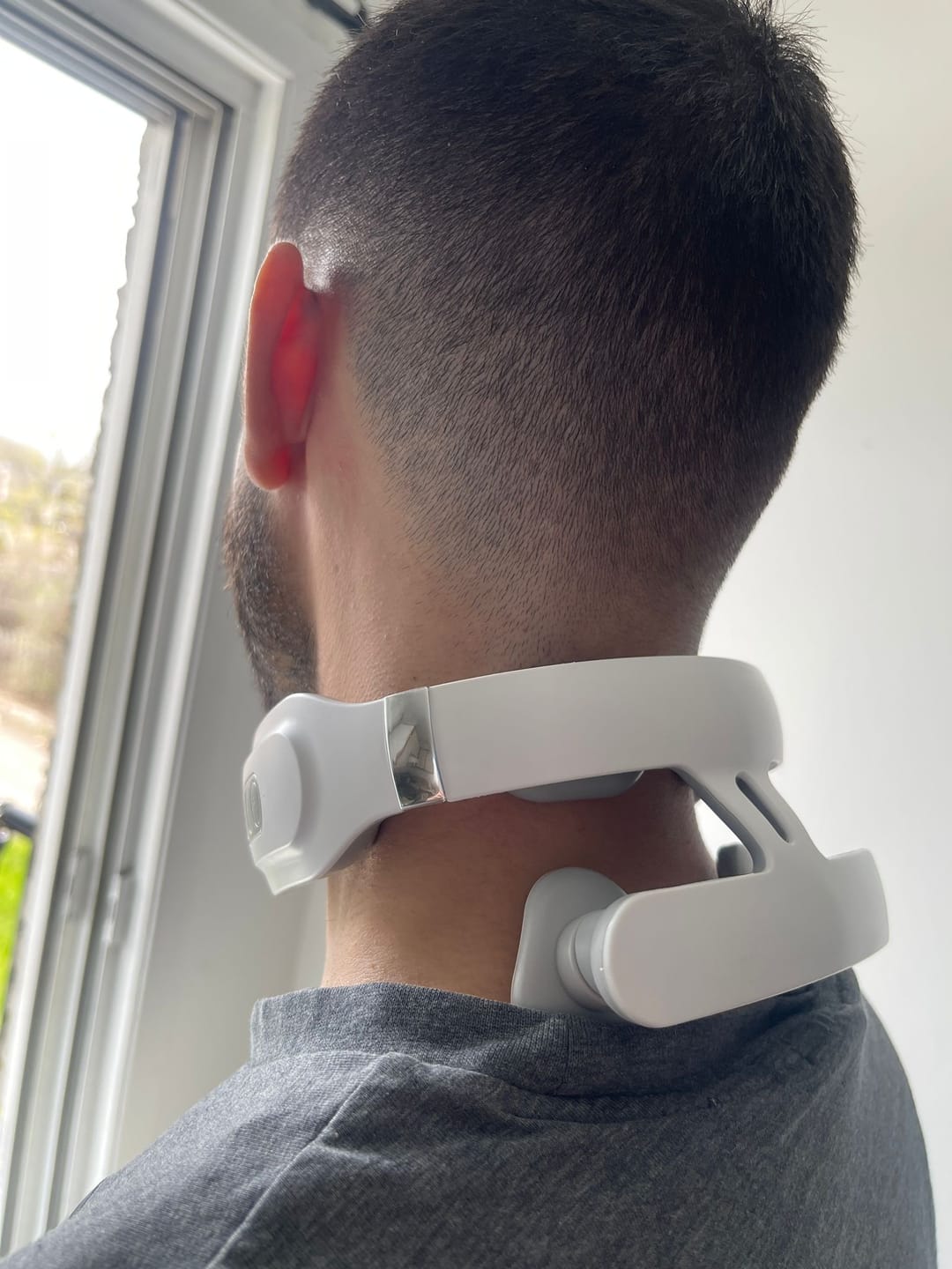 Man använder nackmassageapparat mot nacksmärta och spända muskler – effektiv lindring med värme och impulsmassage.