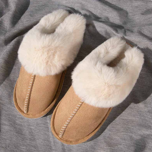 Närbild på varmfodrade tofflor i beige med tjock fuskpäls